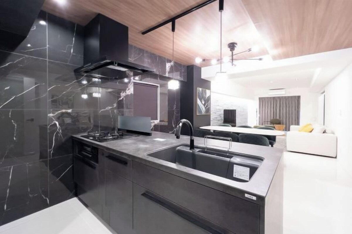 A modern kitchen with a large island, stainless steel appliances, and a sleek design.