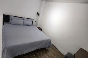 A bedroom with a bed, a nightstand, and a small table. - Hotel My Cang (Tra Vinh)