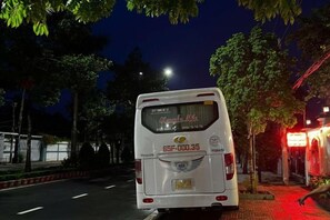 A white bus parked on a street at night. - Hotel My Cang (Tra Vinh)