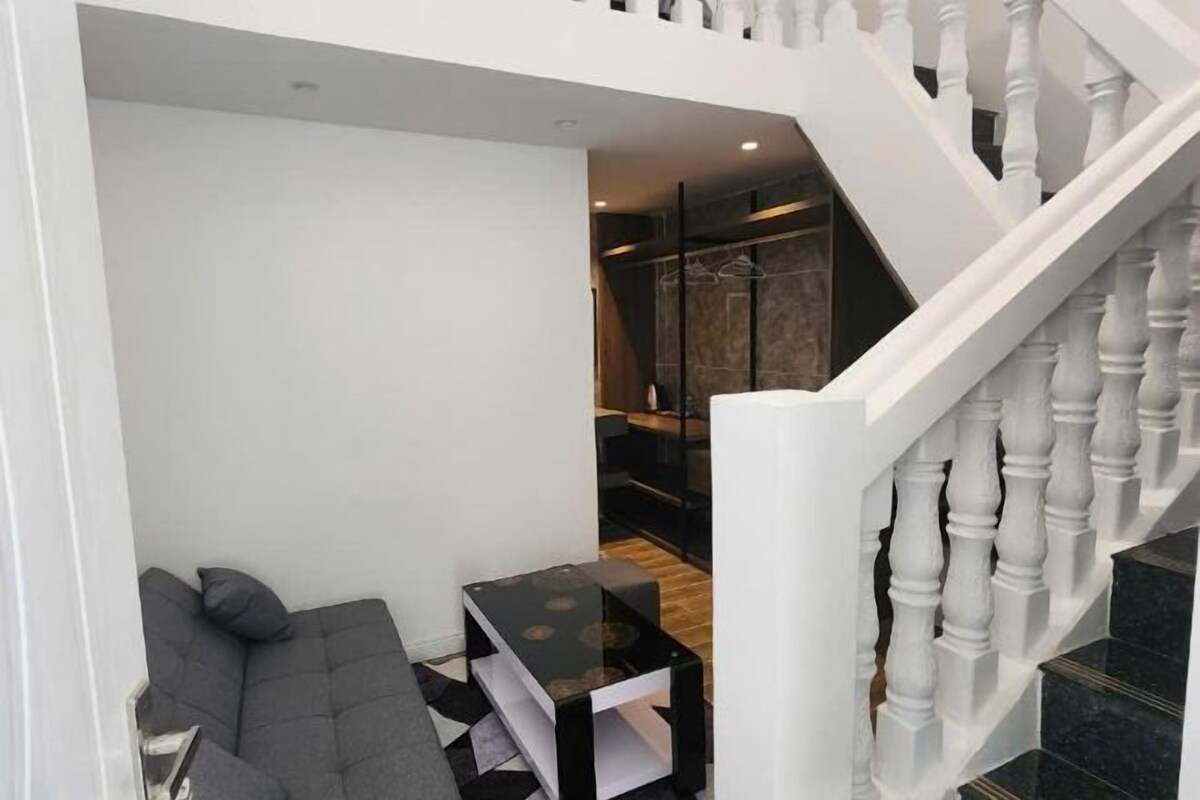 A modern interior with a staircase, a seating area, and a dining table.