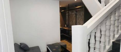 A modern interior with a staircase, a seating area, and a dining table.