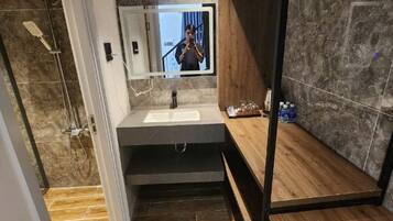 Un bagno moderno con un grande specchio, un lavandino e una doccia.