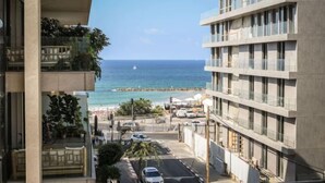 A high-rise hotel with a view of the ocean and beach. - Chic 3BR Apt with Balcony, Mamad (Tel Aviv)