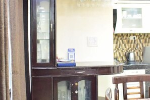 A kitchen with a microwave, a coffee maker, and a cabinet with a blue item on top. - Rudhraksh Villa 4BR- Perfect Vacay Villa (Mussoorie)