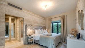 A bedroom with a large bed, bedside tables, a nightstand, a dresser, a mirror, and a view of greenery outside. - All About La Boheme (Benahavis)