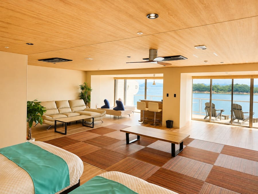 Un'ampia zona giorno con divano, tavolino da caffè e vista sul mare attraverso ampie finestre.