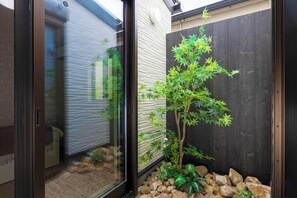 A small garden with a bonsai tree, a wooden fence, and a stone pathway. - EI・RIN (Osaka)