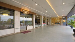 A restaurant with a modern interior, large windows, and a clean, spacious layout. - Hotel Saubhagya Ahmedabad (Ahmedabad)