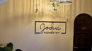 Un mur sur lequel est affiché un panneau indiquant : « Jodene, hébergement chez l’habitant ».