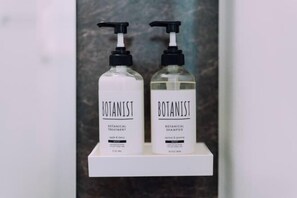 Twee flessen Botanist-producten op een wit schap.
