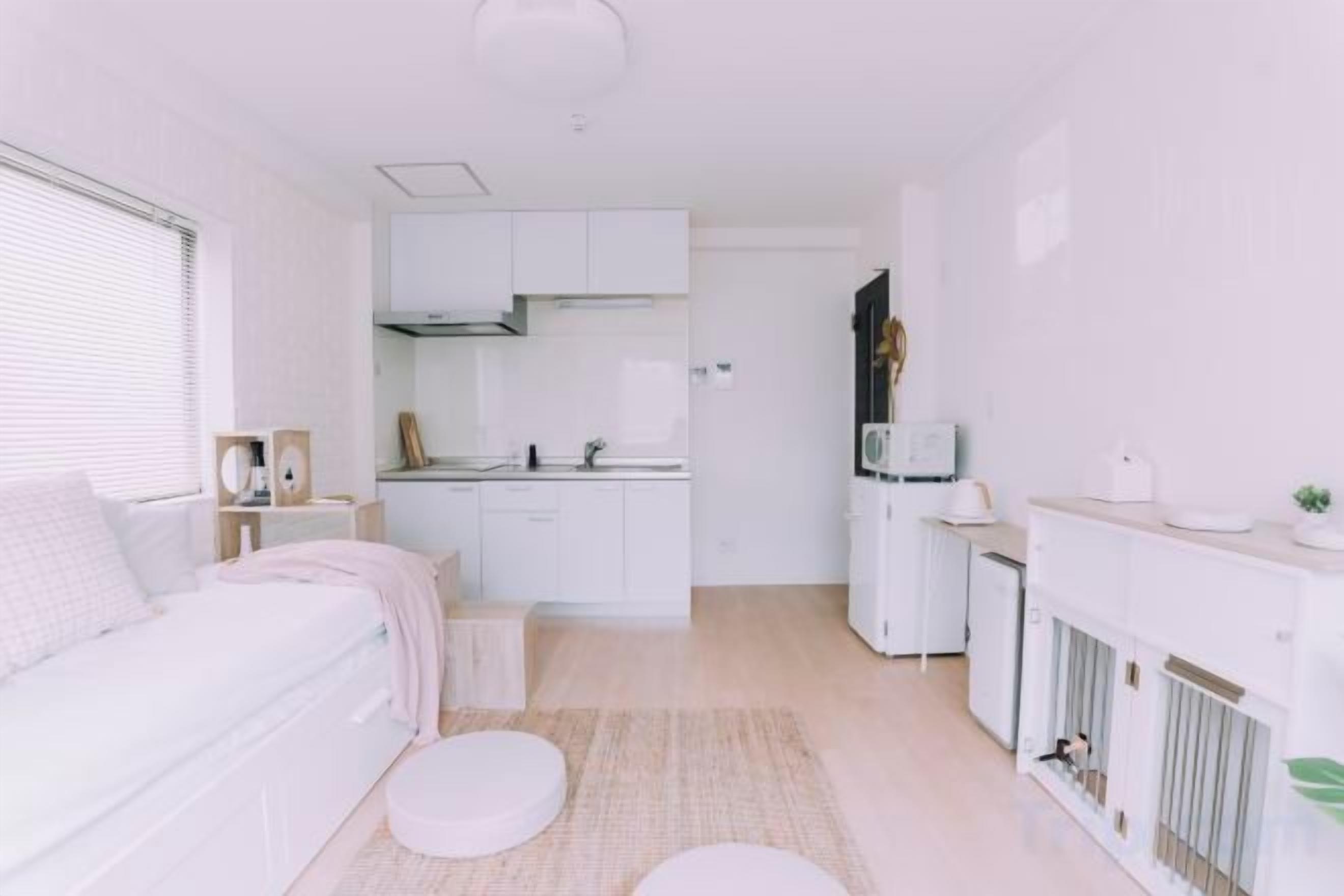 A compact living space with a kitchenette, a dining area, and a bed.