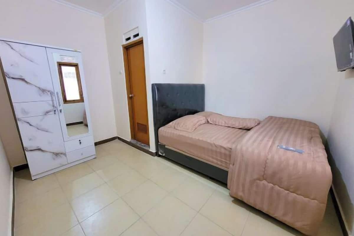 A bedroom with a bed, a wardrobe, and a door.