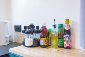 A kitchen counter with various condiments and a coffee maker. - TT63/2 cozy private house near the city (Chiang Mai)