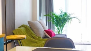 A modern room with a sofa, a small round table, a lamp, and a potted plant. - TT63/2 cozy private house near the city (Chiang Mai)