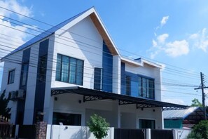 A modern two-story house with a covered porch, large windows, and a brick foundation. - TT63/2 cozy private house near the city (Chiang Mai)