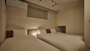 A hotel room with two beds, a window, and a ceiling light fixture. - 1 stop to Shinjuku 13 min to Shibuya Private house rental LUXU Urban Shinjuku (Tokyo)