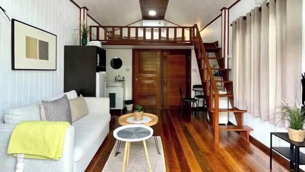 A cozy living room with a loft bed, a staircase, a sofa, a coffee table, and a dining area. - Anna River Home A3 (Bangkok)