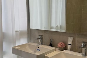 A bathroom with a double sink, a mirror, and a towel rack. - DutaVilla Putrajaya (Putrajaya)