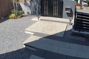 A paved outdoor area with a gate, a mailbox, and a small plant. - star residence (Inzai)