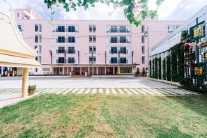 A multi-story building with a flat facade, a central entrance, and a paved courtyard. - Wangkaew Hotel, Phitsanulok (Phitsanulok)