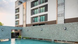 A modern building with a swimming pool and a covered walkway. - Wangkaew Hotel, Phitsanulok (Phitsanulok)