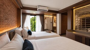 A hotel room with two beds, a brick wall, a window with curtains, and a radiator. - Wangkaew Hotel, Phitsanulok (Phitsanulok)