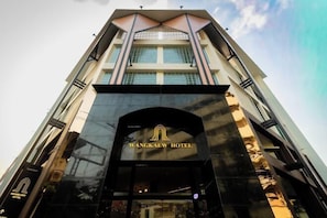 Das Wangkeaw Hotel mit moderner Architektur, großen Glasfenstern und einem markanten Eingang.
