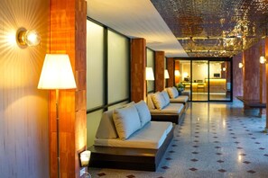 A hotel lobby with a row of sofas, a reception desk, and a patterned floor. - Wangkaew Hotel, Phitsanulok (Phitsanulok)