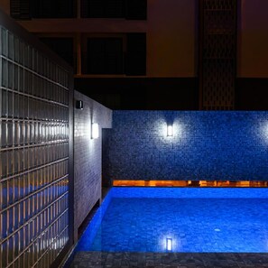 A swimming pool with blue tiles and a metal fence. - Wangkaew Hotel, Phitsanulok (Phitsanulok)