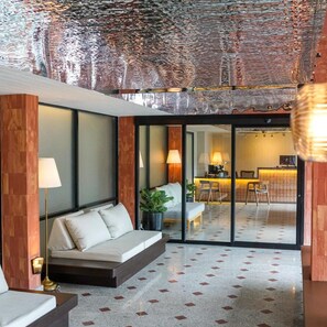 Een modern interieur met een bank, een lamp en uitzicht op een keukenhoek.
