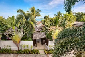 A tropical resort with multiple bungalow-style accommodations surrounded by lush greenery and palm trees.