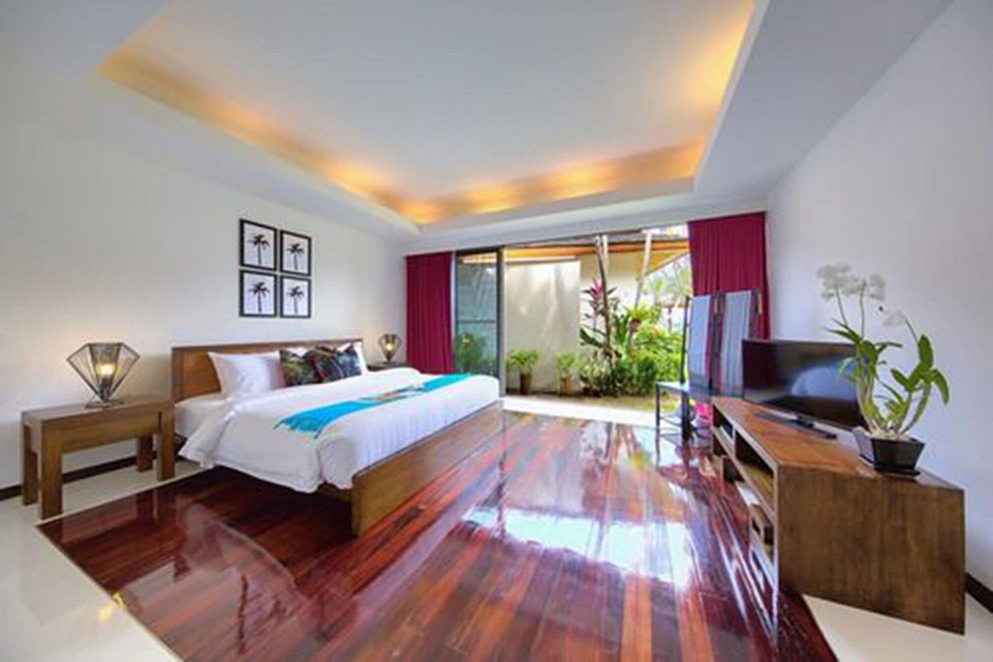 A hotel room with a bed, a desk, a TV, and a view of the outdoors.