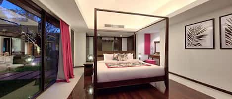 A modern bedroom with a four-poster bed, large windows, and artwork on the walls.