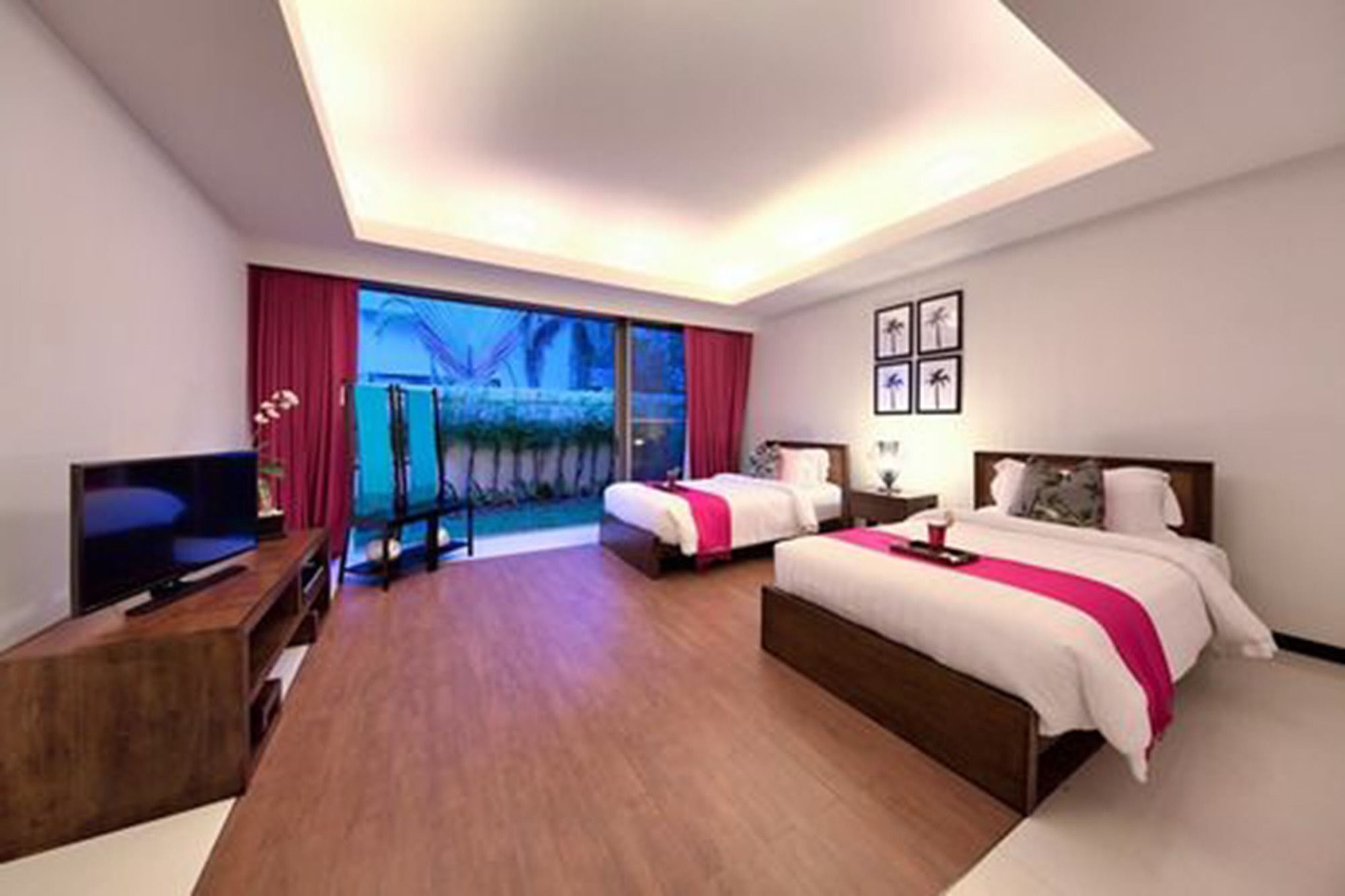 Habitación de hotel con dos camas, un televisor y un ventanal con vistas.