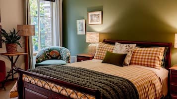 A bedroom with a bed, a chair, a lamp, and a window.