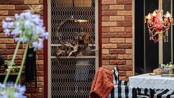 A brick exterior with a metal gate, a table with a white tablecloth, and a chandelier.