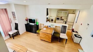 Un espace de vie compact comprenant un coin repas, une kitchenette et un téléviseur.