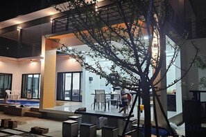 Un espace intérieur moderne comprenant un coin repas, un escalier et une sculpture en forme d’arbre.