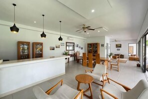 A spacious hotel lobby with a reception desk, seating area, and a ceiling fan. - Ananda Villa Yeh Gangga by The Lavana (4 Bedroom Villa with Private Pool) (Bali)