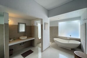 Une salle de bain moderne avec une baignoire sur pieds, un meuble-lavabo et un miroir.
