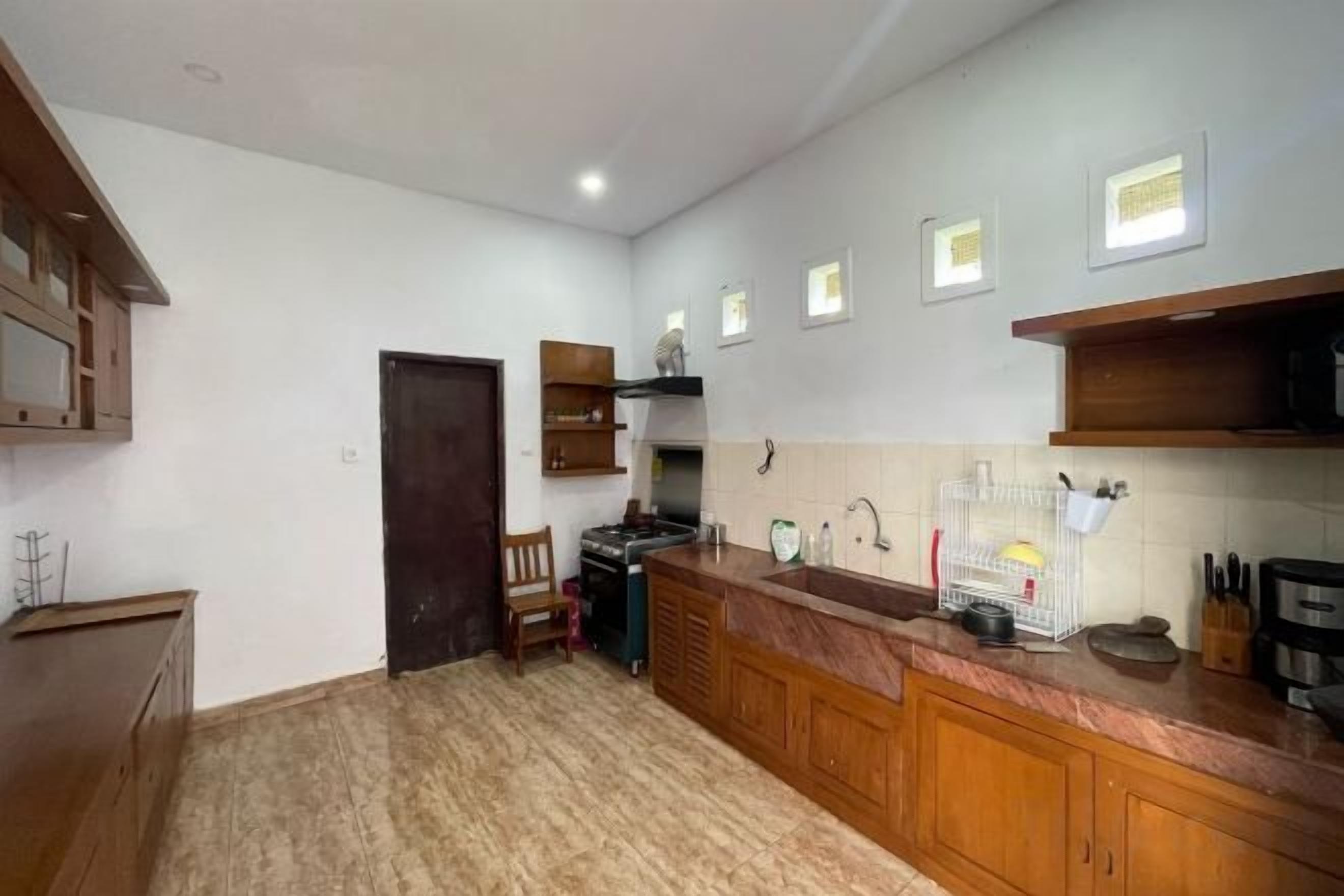 A kitchen with wooden cabinets, a countertop, and a stove.