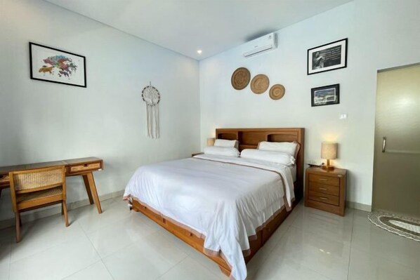 A bedroom with a bed, bedside table, chair, and wall decorations. - Ananda Villa Yeh Gangga by The Lavana (4 Bedroom Villa with Private Pool) (Bali)