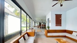 Un salon moderne avec un canapé, une table basse et de grandes fenêtres.