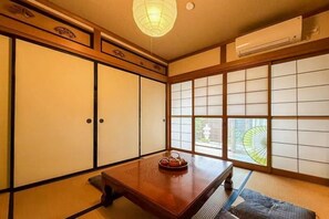 A traditional Japanese room with tatami flooring, sliding doors, and a table with a tea set. - TAKAYAMA KAEDENOYADO (Takayama)