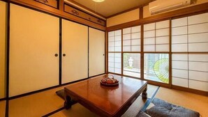 A traditional Japanese room with tatami flooring, shoji screens, a wooden table with a tea set, and a ceiling fan. - TAKAYAMA KAEDENOYADO (Takayama)