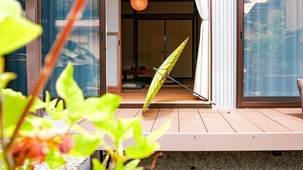 A modern building with a wooden deck, a sliding glass door, and a hanging lantern. - TAKAYAMA KAEDENOYADO (Takayama)