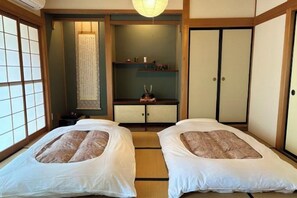 A traditional Japanese-style room with tatami flooring, two tatami beds, a shoji screen, and a sliding door. - TAKAYAMA KAEDENOYADO (Takayama)