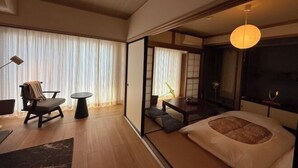 A traditional Japanese-style room with tatami flooring, a low table, a cushioned bench, and a hanging paper lantern. - TAKAYAMA KAEDENOYADO (Takayama)