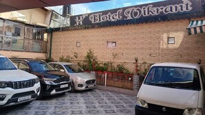 Ein Parkplatz vor dem Hotel Vikrant mit mehreren parkenden Autos.