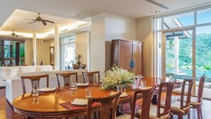 Un comedor con una mesa y sillas de madera, un armario y vistas al exterior.